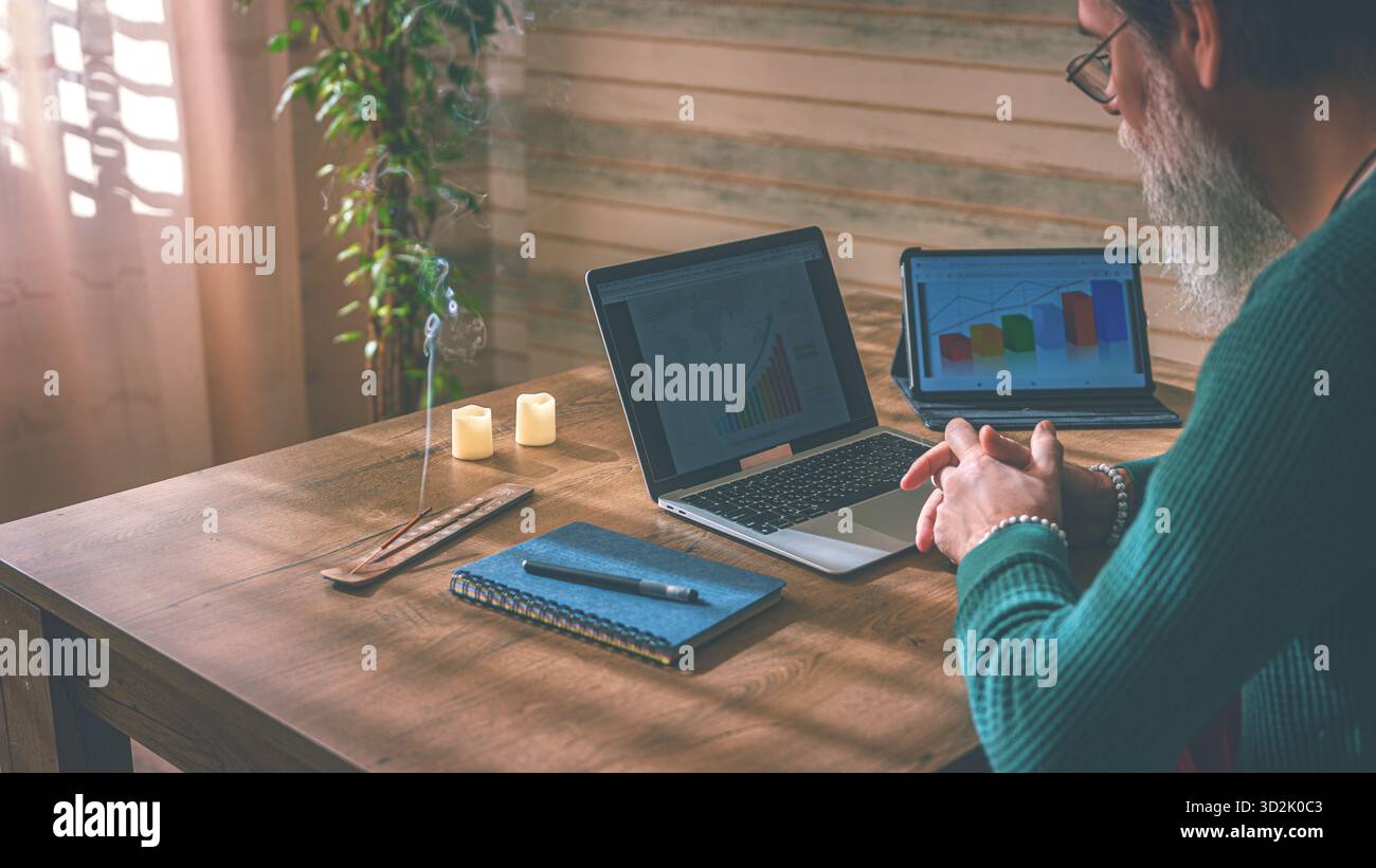 Murmure de pensée. La fumée d'un bâton d'arôme dérive entre les mains pliées, les lampes en forme de bougie projettent de tendres halos sur le bureau en bois Banque D'Images