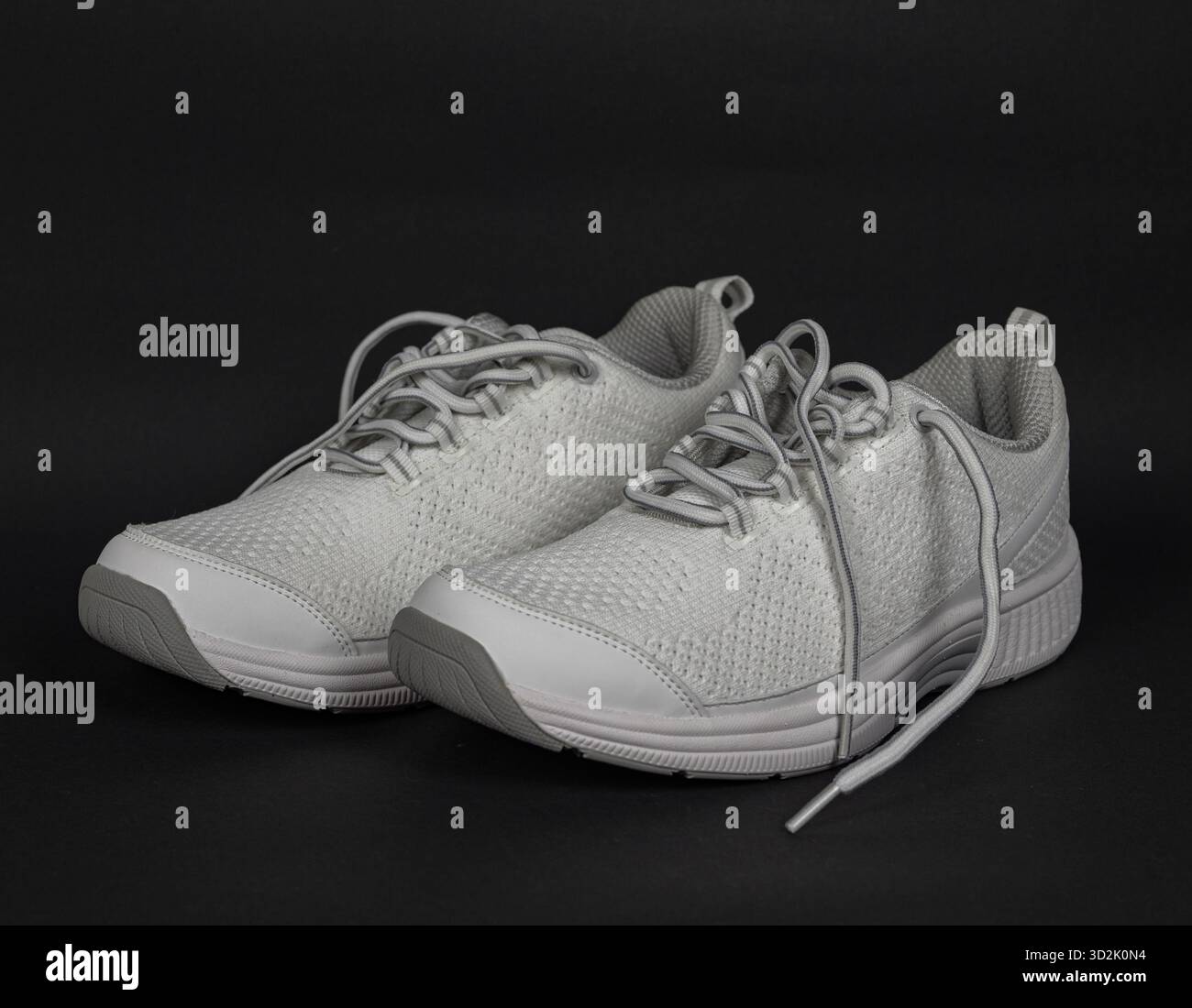 Élégantes baskets en maille pour femme avec lacets blancs, mêlant minimalisme et fonctionnalité Banque D'Images