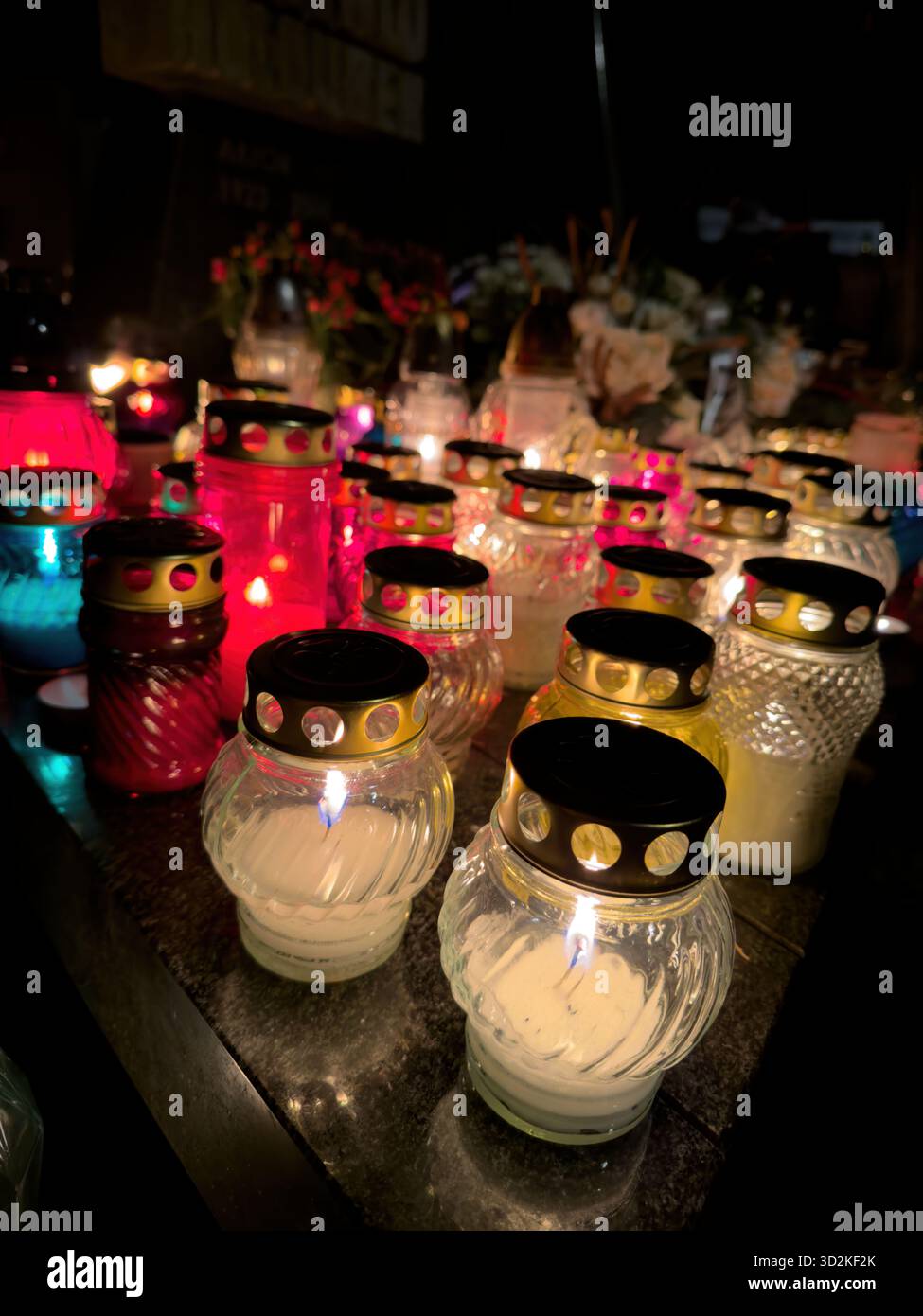 Toutes les bougies de la Fête des âmes qui brillent parmi les tombes symbolisent le souvenir, la spiritualité et l'amour éternel. Scène commémorative honorant le défunt avec des fleurs - Image de stock capturée avec un smartphone