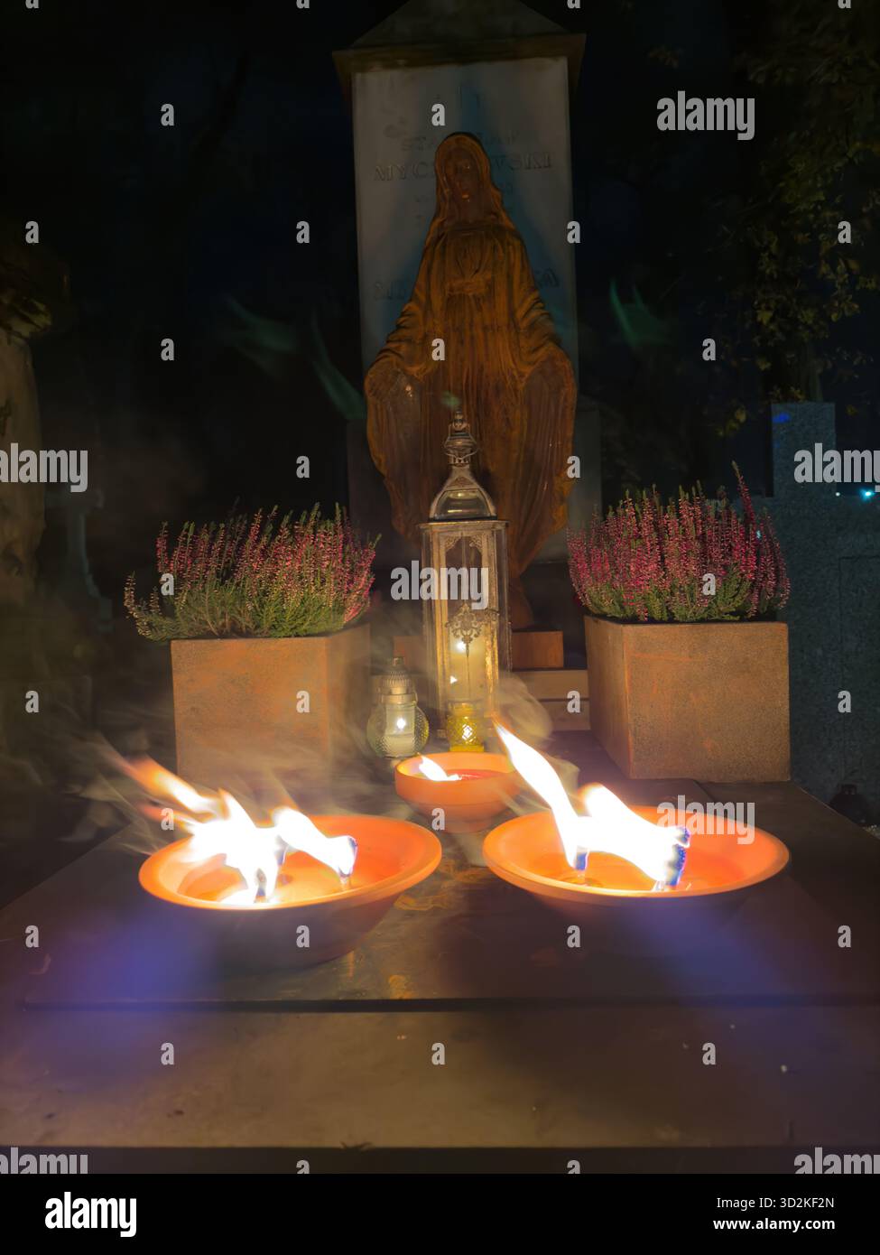 Le mémorial du jour de toutes les âmes rempli de bougies et de fleurs brillantes représente le souvenir, la foi et l'espoir. Atmosphère paisible de cimetière que les gens honorent - Image de stock capturée avec un smartphone