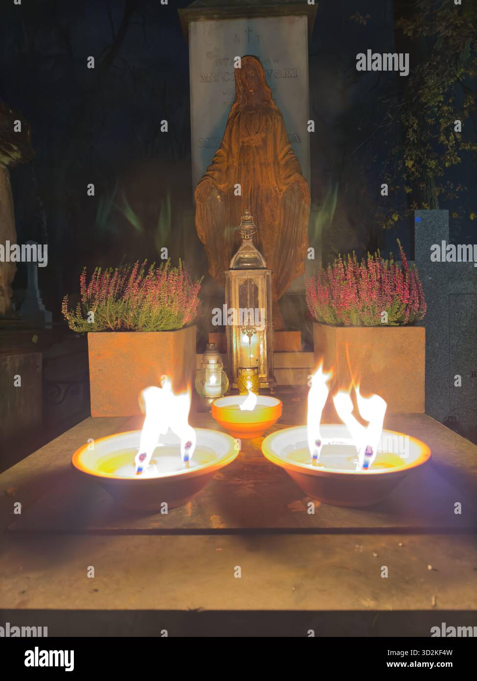 Le mémorial du jour de toutes les âmes rempli de bougies et de fleurs brillantes représente le souvenir, la foi et l'espoir. Atmosphère paisible de cimetière que les gens honorent - Image de stock capturée avec un smartphone