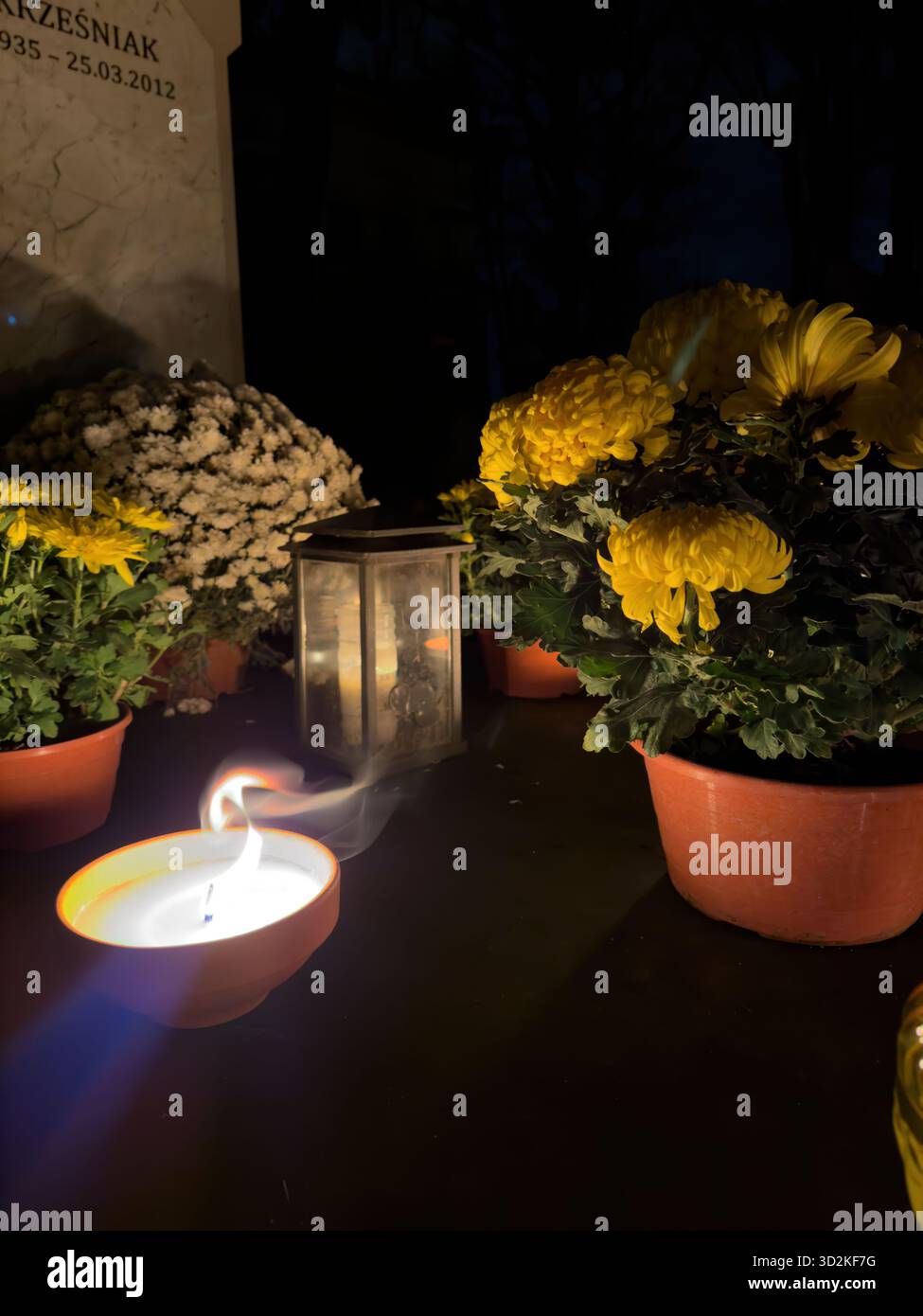 Le mémorial du jour de toutes les âmes rempli de bougies et de fleurs brillantes représente le souvenir, la foi et l'espoir. Atmosphère paisible de cimetière que les gens honorent - Image de stock capturée avec un smartphone