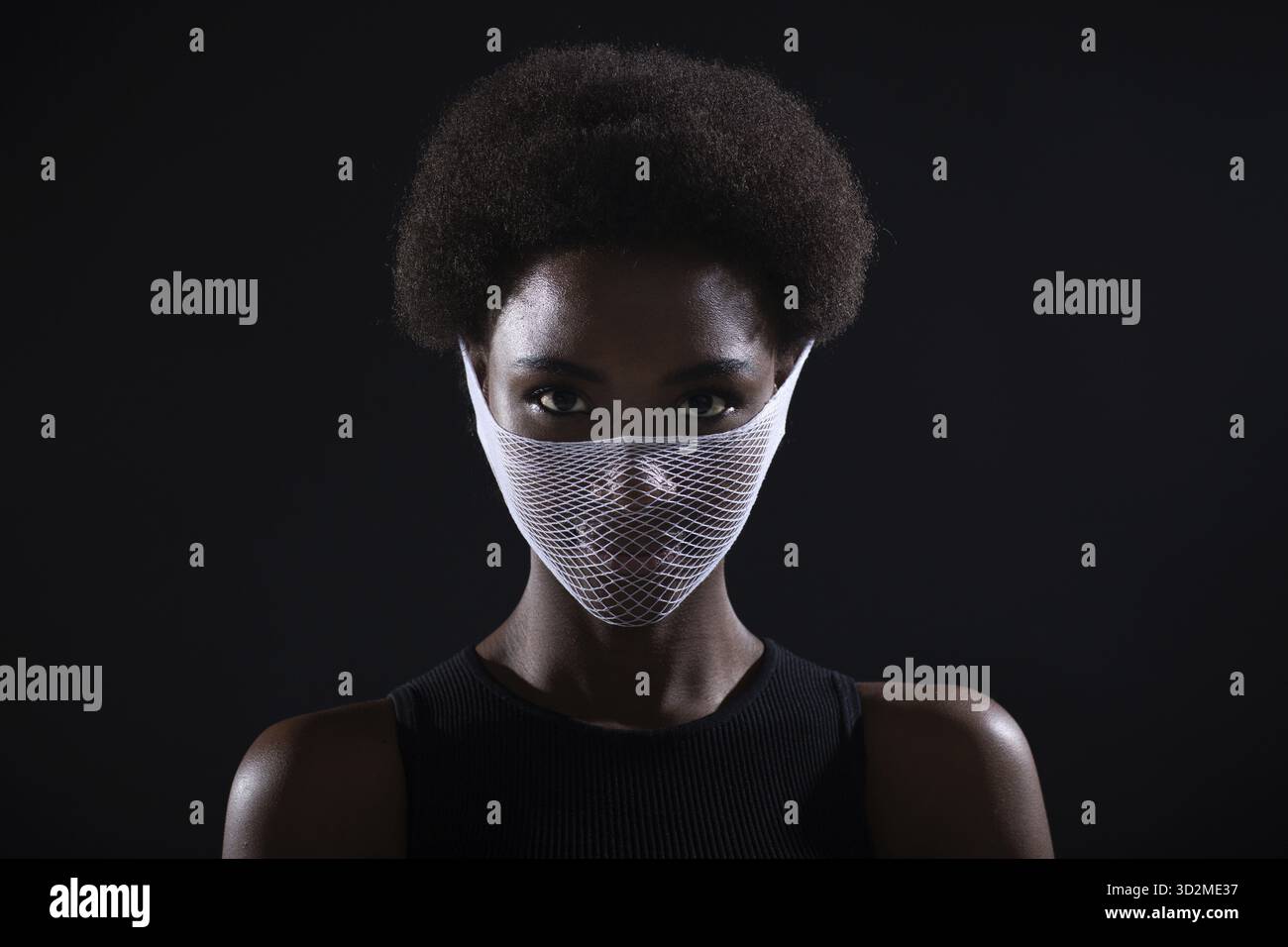 Portrait d'afro-américain peau foncée femme modèle de mode quarantaine médical résille tricoting masque de visage filet grossier. Protection contre le coronavirus Covid-19 Banque D'Images