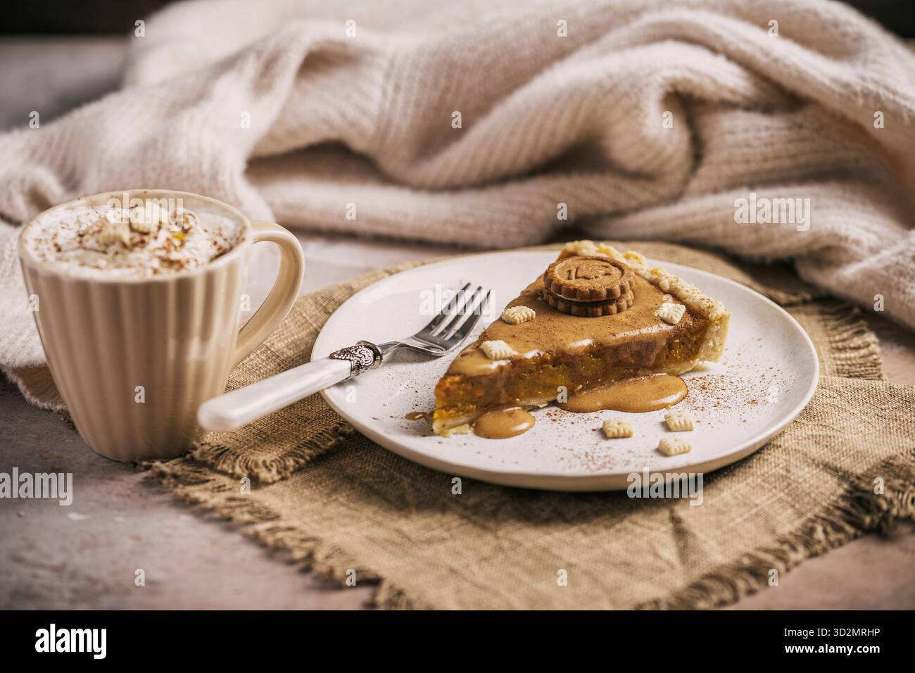 Morceau de tarte à la citrouille avec sauce caramel et biscuits sur un fond clair avec des couleurs vives et chaudes Banque D'Images