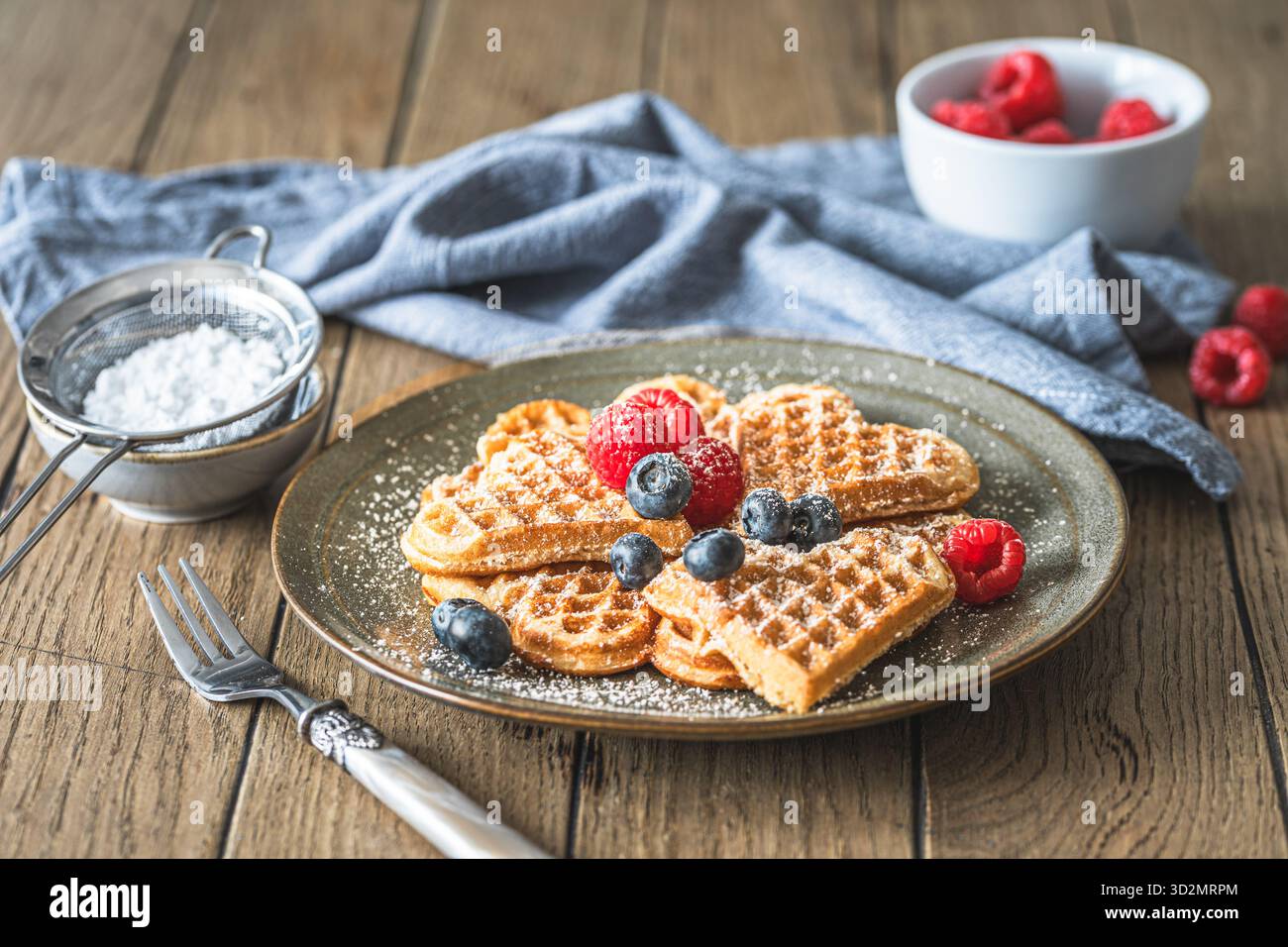 Gaufres maison avec sucre en poudre et baies sur une table en bois Banque D'Images