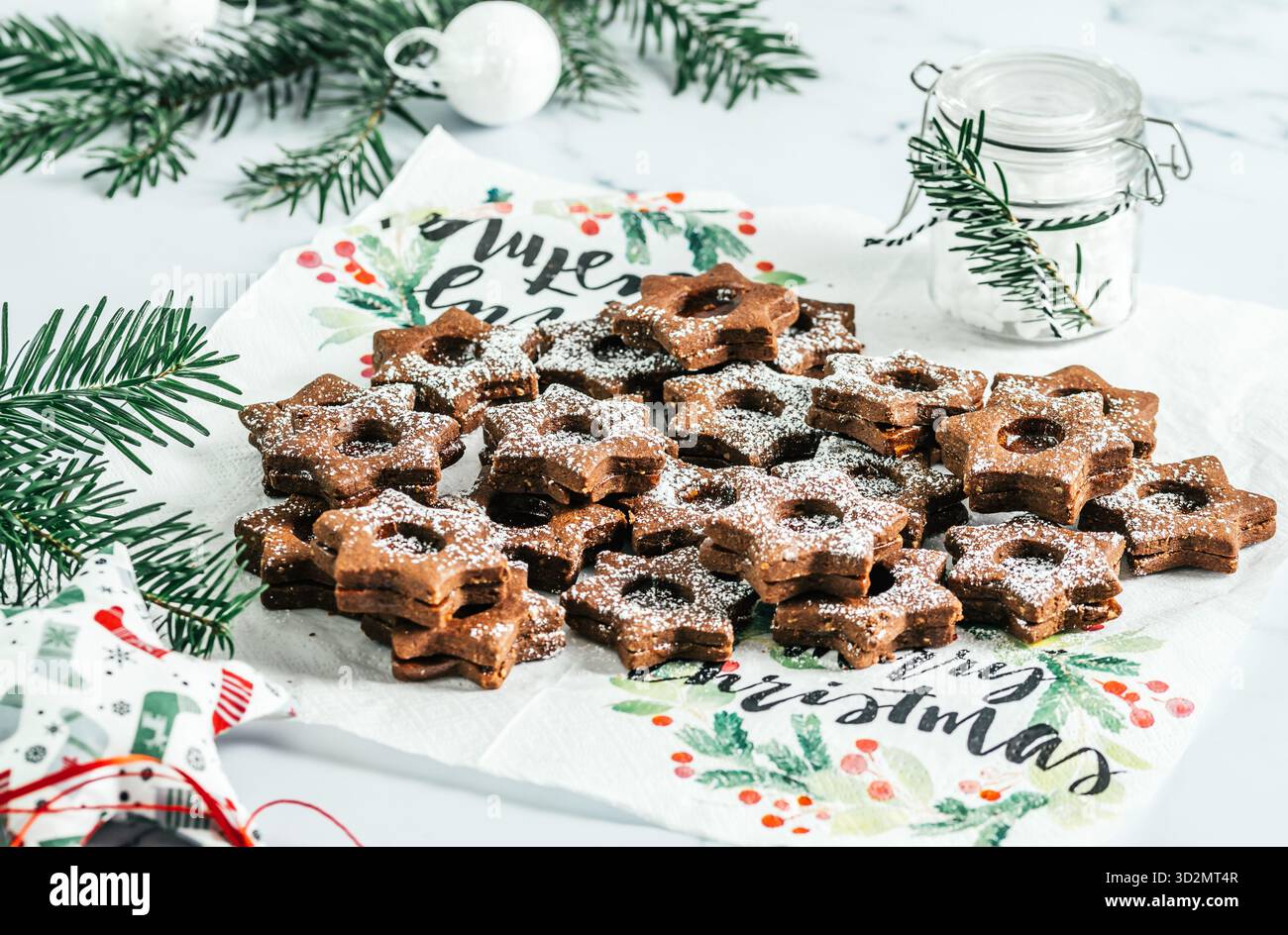 Biscuits de Noël Linz traditionnels remplis de confiture de coing sur fond blanc. Décorer avec des branches de sapin. Banque D'Images
