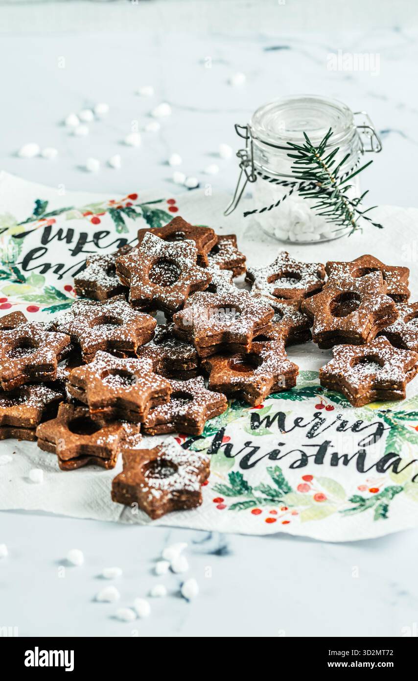 Biscuits de Noël Linz traditionnels remplis de confiture de coing sur fond blanc. Décorer avec des branches de sapin. Banque D'Images