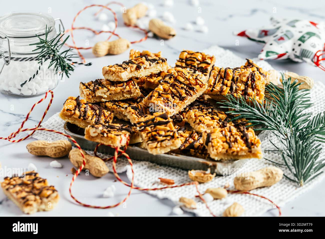 Biscuits au caramel aux arachides faits maison, biscuits de Noël au caramel salé et aux arachides, coupés en rectangles, fond blanc Banque D'Images