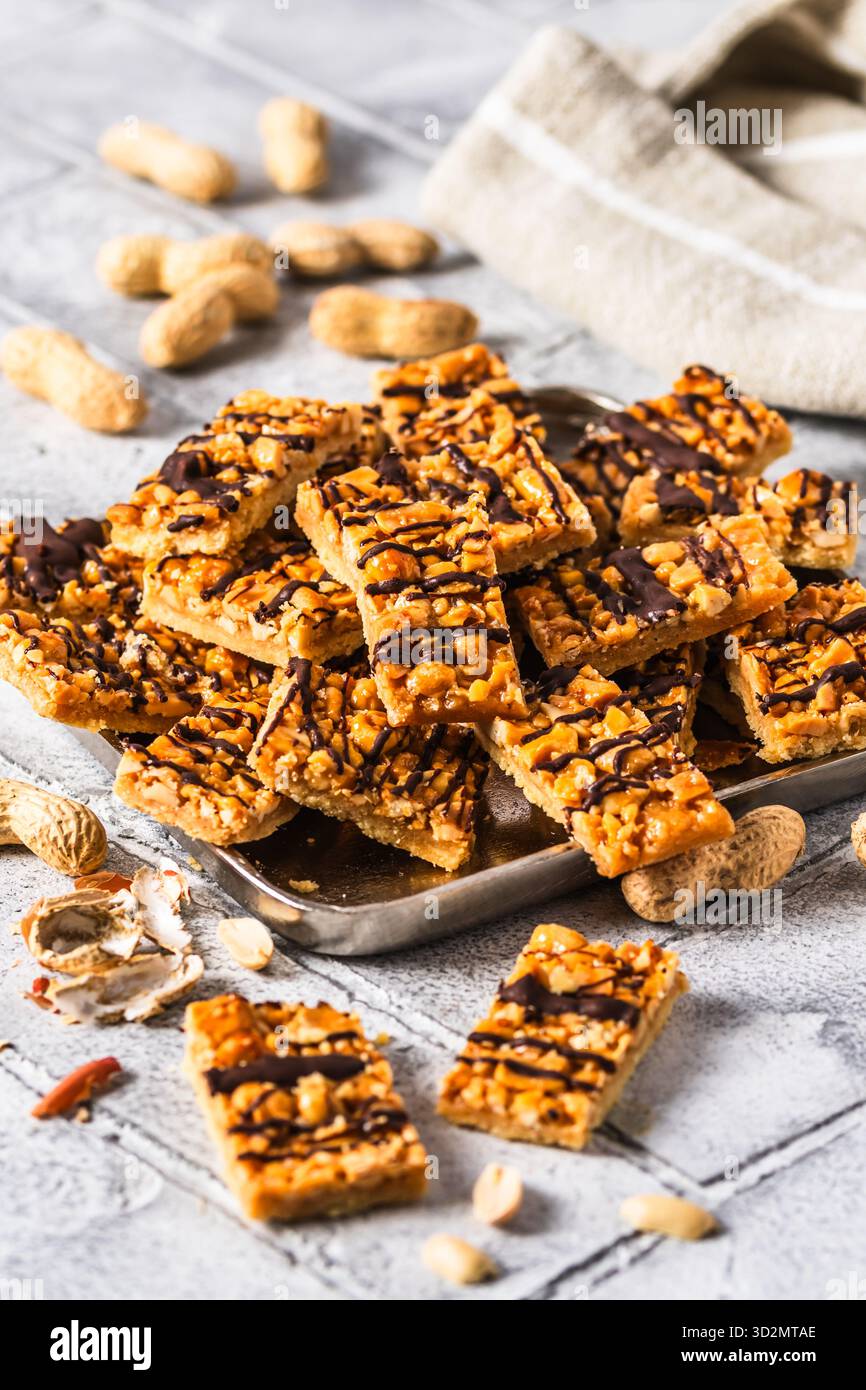 Biscuits faits maison avec caramel salé et cacahuètes, coupés en rectangles, verticaux Banque D'Images
