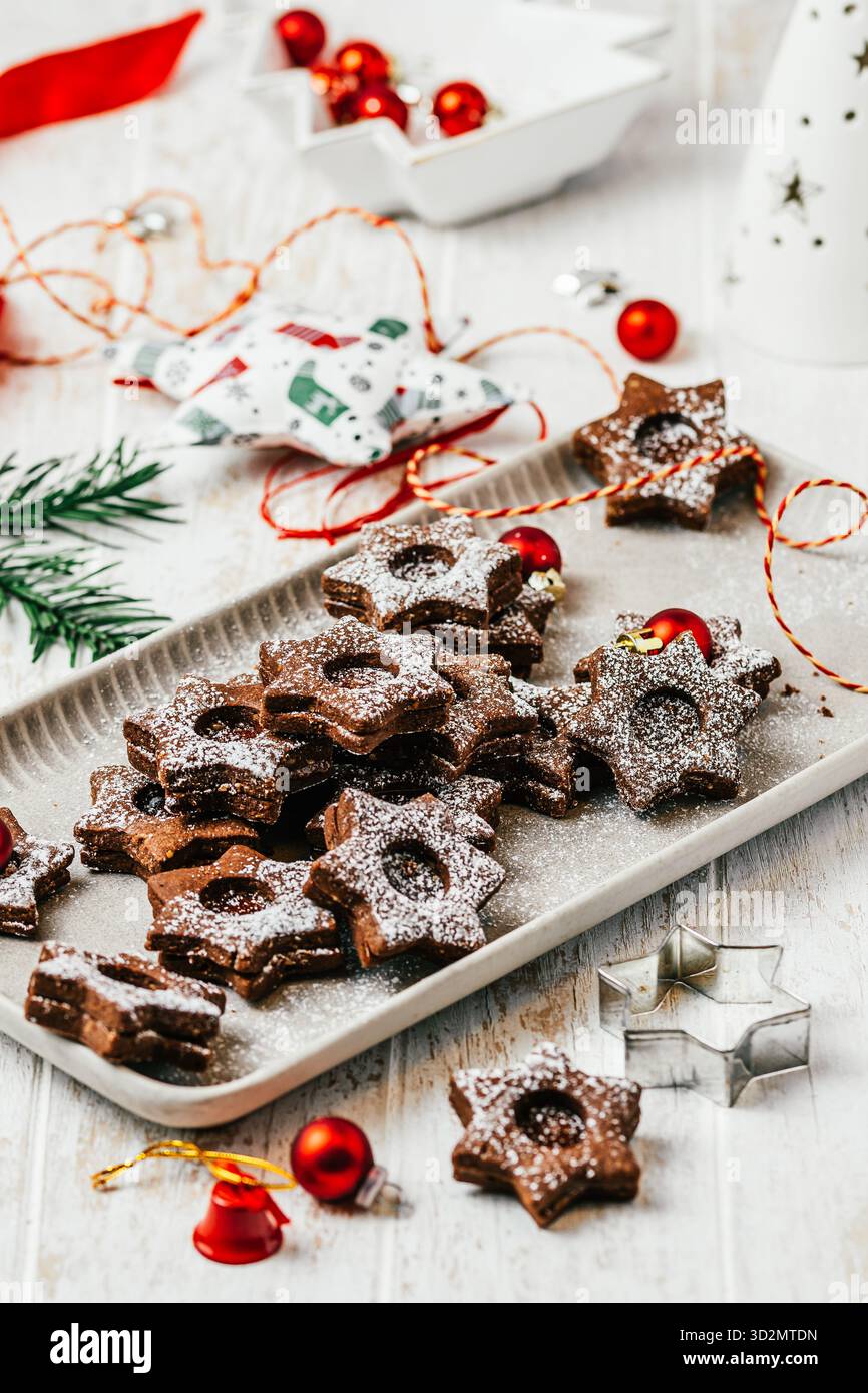 Biscuits de Noël Linz traditionnels remplis de confiture de coing sur fond blanc en bois, décoration christmale, verticale Banque D'Images