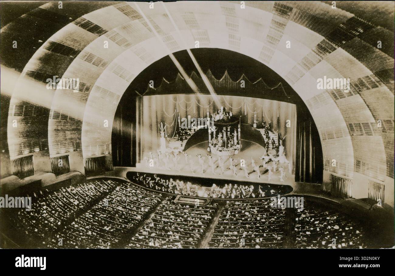 Carte postale représentant l'intérieur du Radio City Music Hall, mettant en vedette une performance sur la scène tournante sous la haute arche du Proscenium, Rockefeller Center, New York City, États-Unis, 1935. Banque D'Images