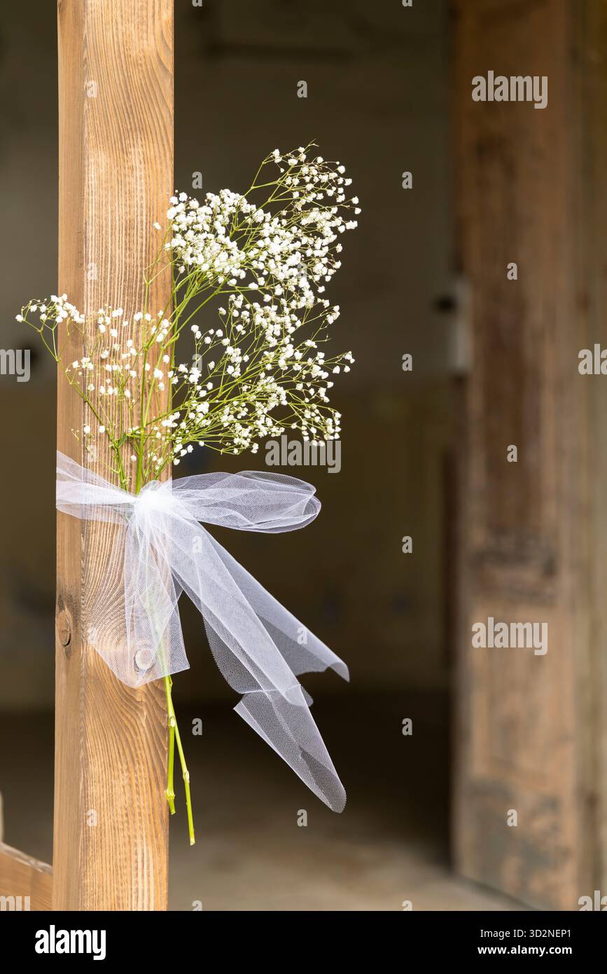 Fleurs de souffle de bébé blanc avec ruban blanc décorant une porte en bois rustique Banque D'Images