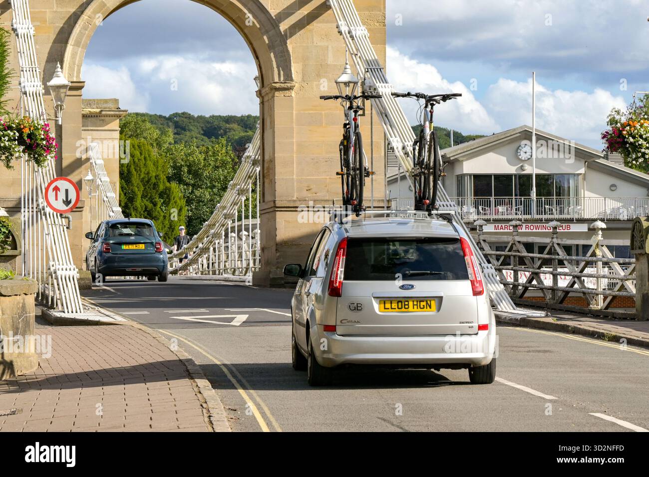 Marlow, Buckinghamshire, Angleterre, Royaume-Uni - 20 juillet 2025 : voiture avec deux vélos sur un porte-vélos de toit conduisant sur le pont à chaînes à Marlow Banque D'Images
