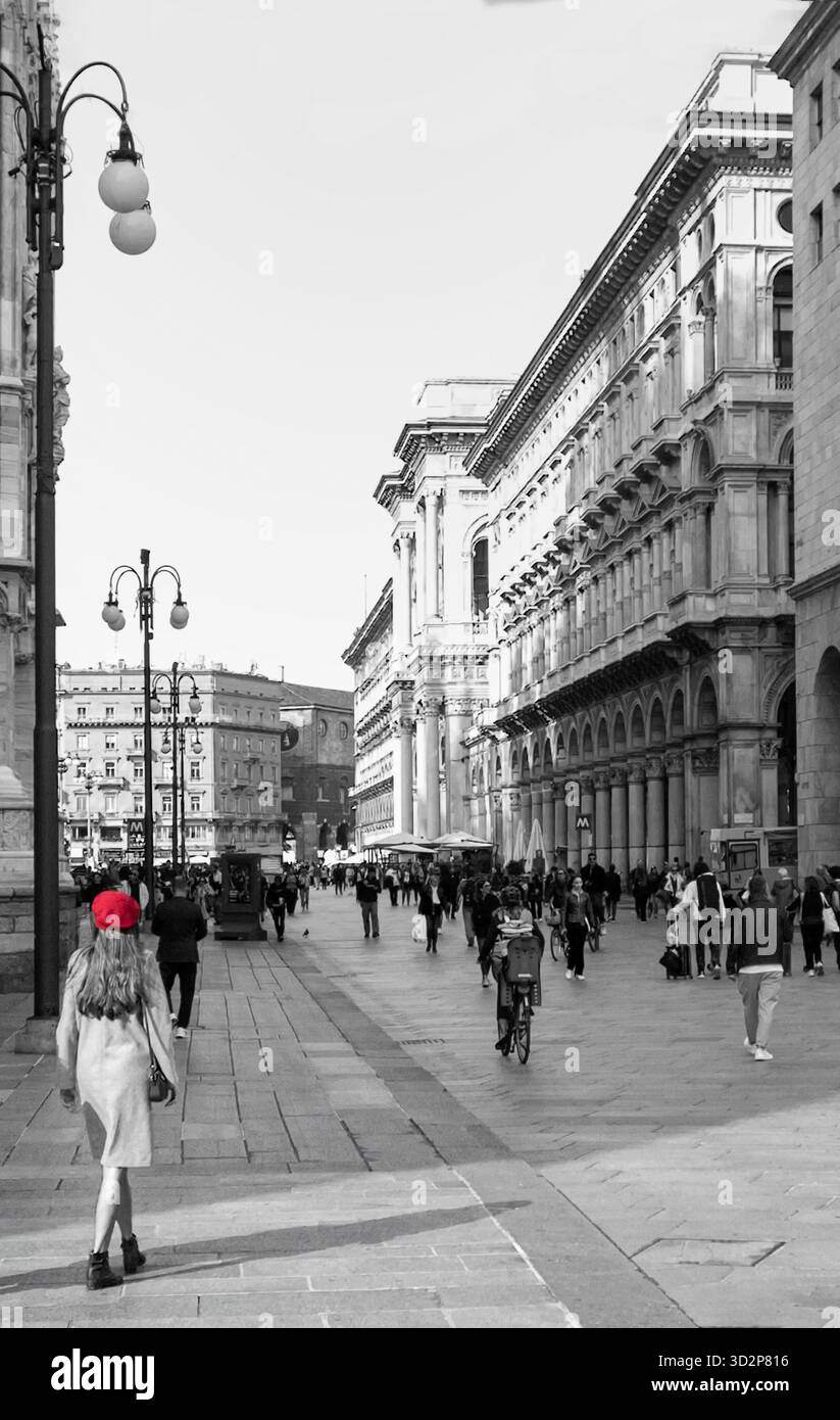 Jeune femme dans un béret rouge marchant dans une rue animée près de la Galleria Vittorio Emanuele II à Milan, Italie, Banque D'Images