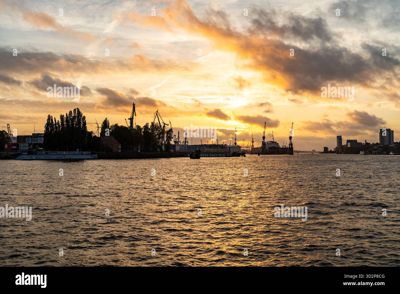 Grues portuaires de Hambourg et bateaux au coucher du soleil sur l'Elbe Banque D'Images