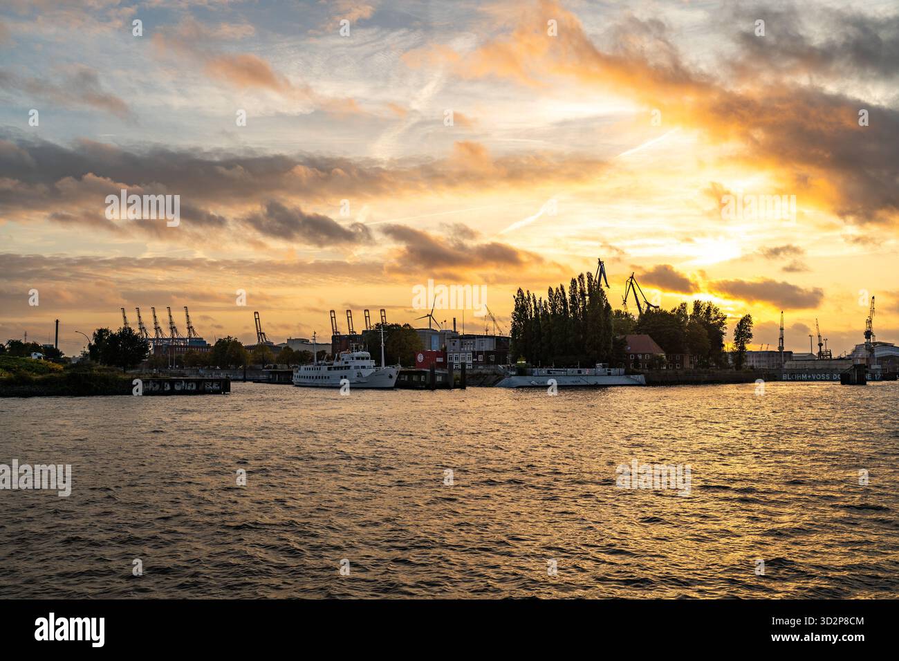 Grues portuaires de Hambourg et bateaux au coucher du soleil sur l'Elbe Banque D'Images