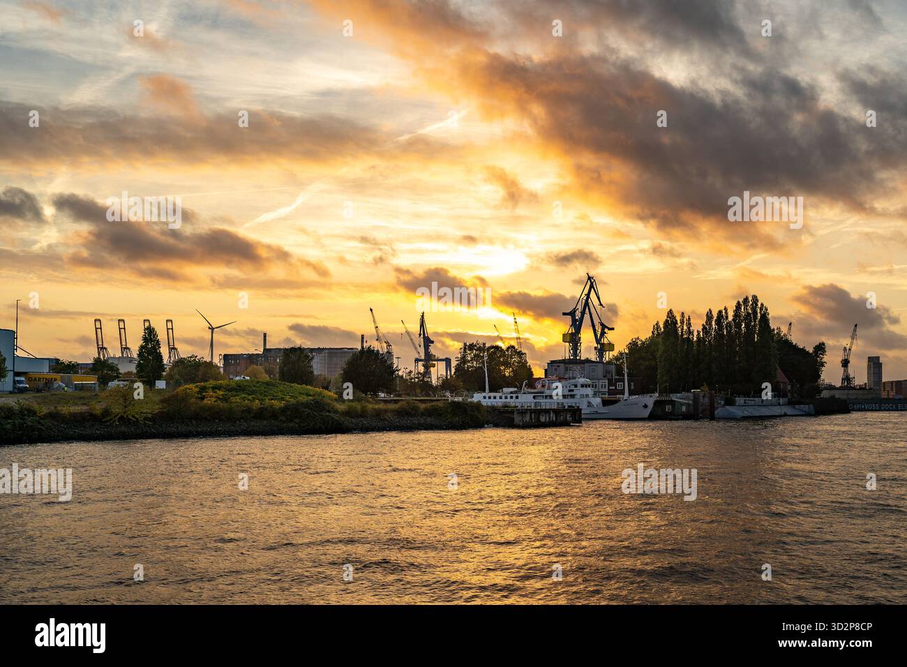Grues portuaires de Hambourg et bateaux au coucher du soleil sur l'Elbe Banque D'Images