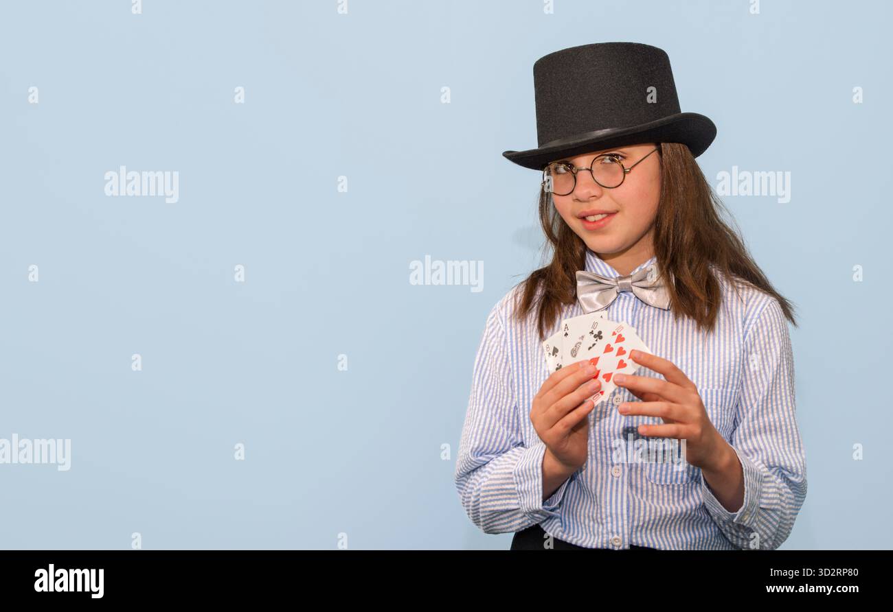 Fille dans un costume de magicien avec des cartes et un chapeau haut de gamme. 10-12 ans. espace pour le texte. Banque D'Images