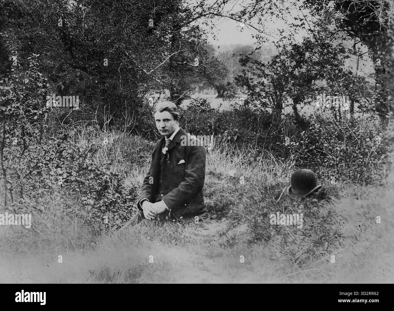Jeune homme irlandais assis sur le sol à côté de son chapeau melon, vers 1895. Banque D'Images