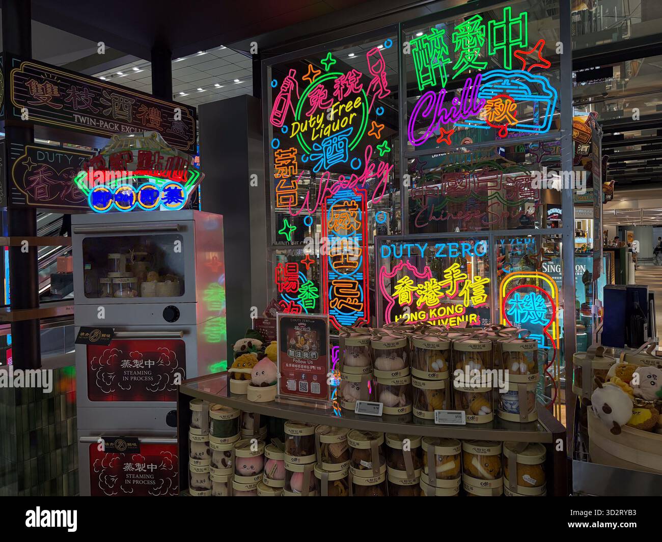 La boutique hors taxes de l'aéroport international de Hong Kong propose des en-cas traditionnels et des souvenirs sous des panneaux lumineux au néon, mettant en valeur la culture locale. Banque D'Images