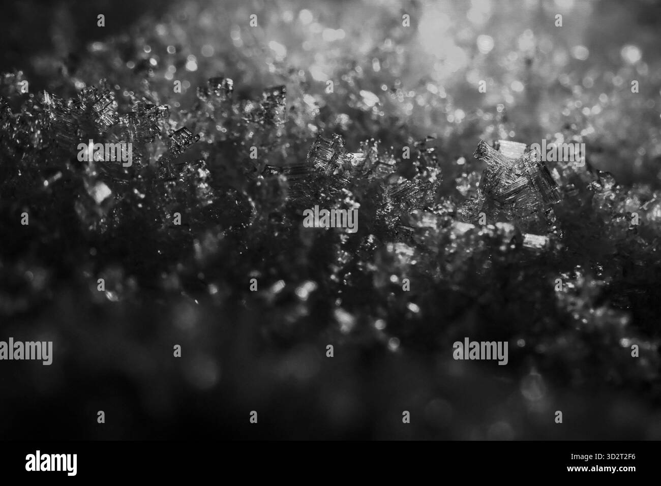 Macro texture complexe de glace étincelante et cristaux de neige, modèle hivernal froid captivant. Les détails granulaires de la surface évoquent la sensation de refroidissement de pur Banque D'Images