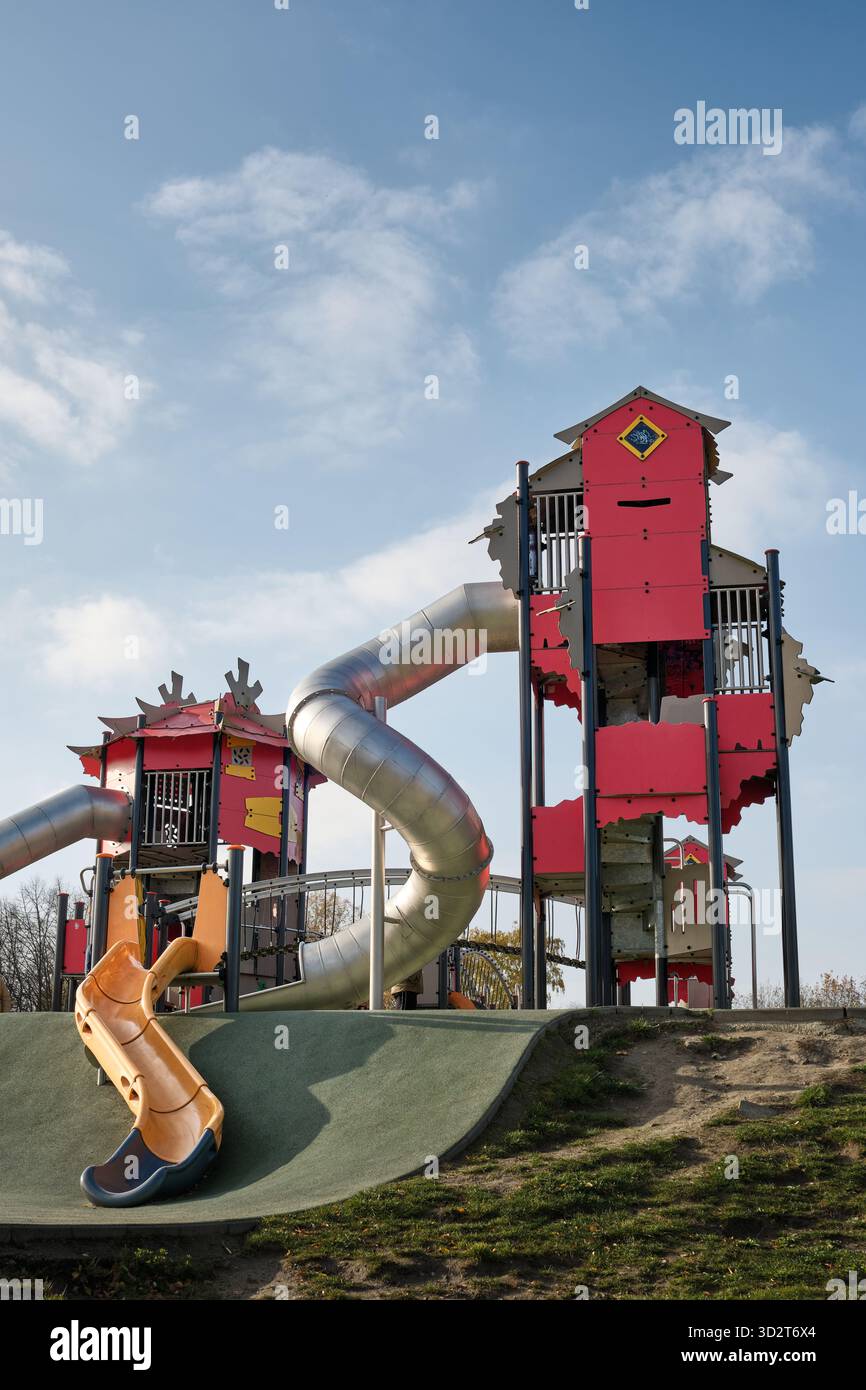 Aire de jeux extérieure moderne avec de grandes tours, des tunnels et des toboggans dans un parc urbain à Lodz, en Pologne, conçu pour les loisirs des enfants et les loisirs en famille. Banque D'Images