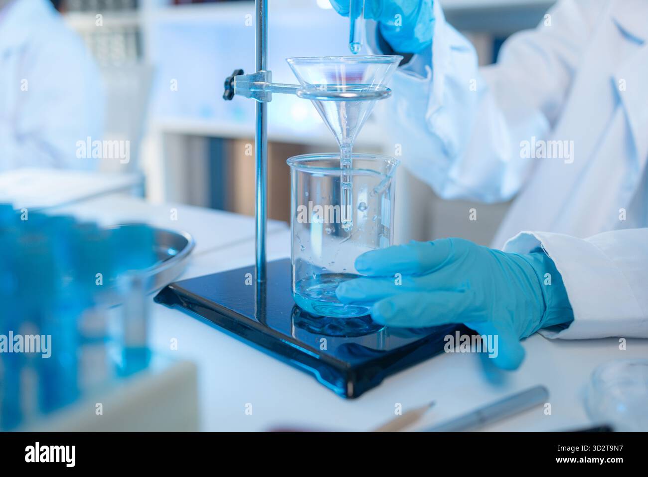 Chercheur en chimie dans un laboratoire entouré d'équipements scientifiques et de tubes à essai, représentant l'innovation, le développement scientifique et moderne Banque D'Images