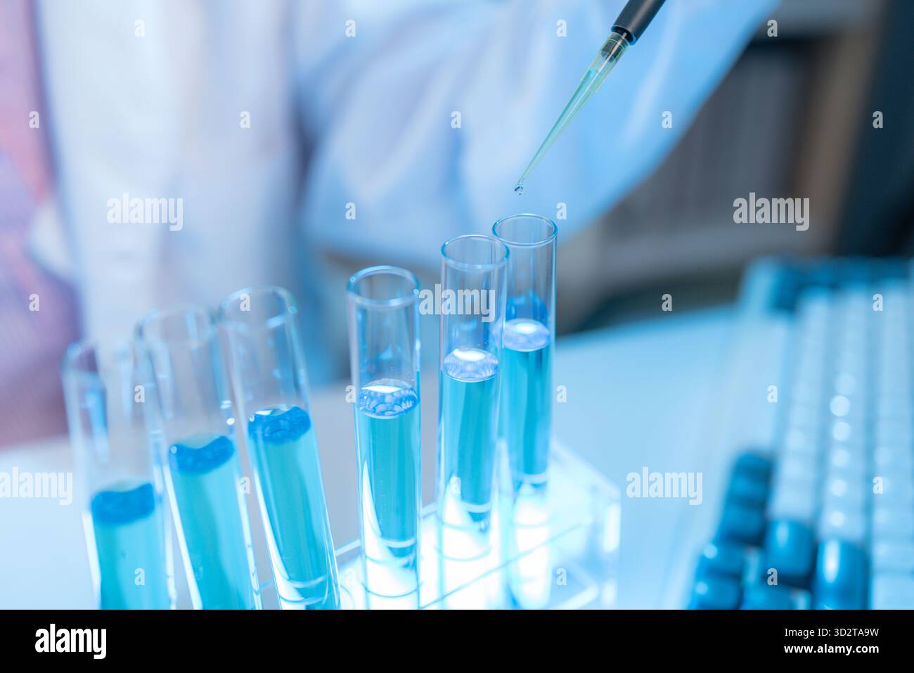 Chercheur en chimie dans un laboratoire entouré d'équipements scientifiques et de tubes à essai, représentant l'innovation, le développement scientifique et moderne Banque D'Images