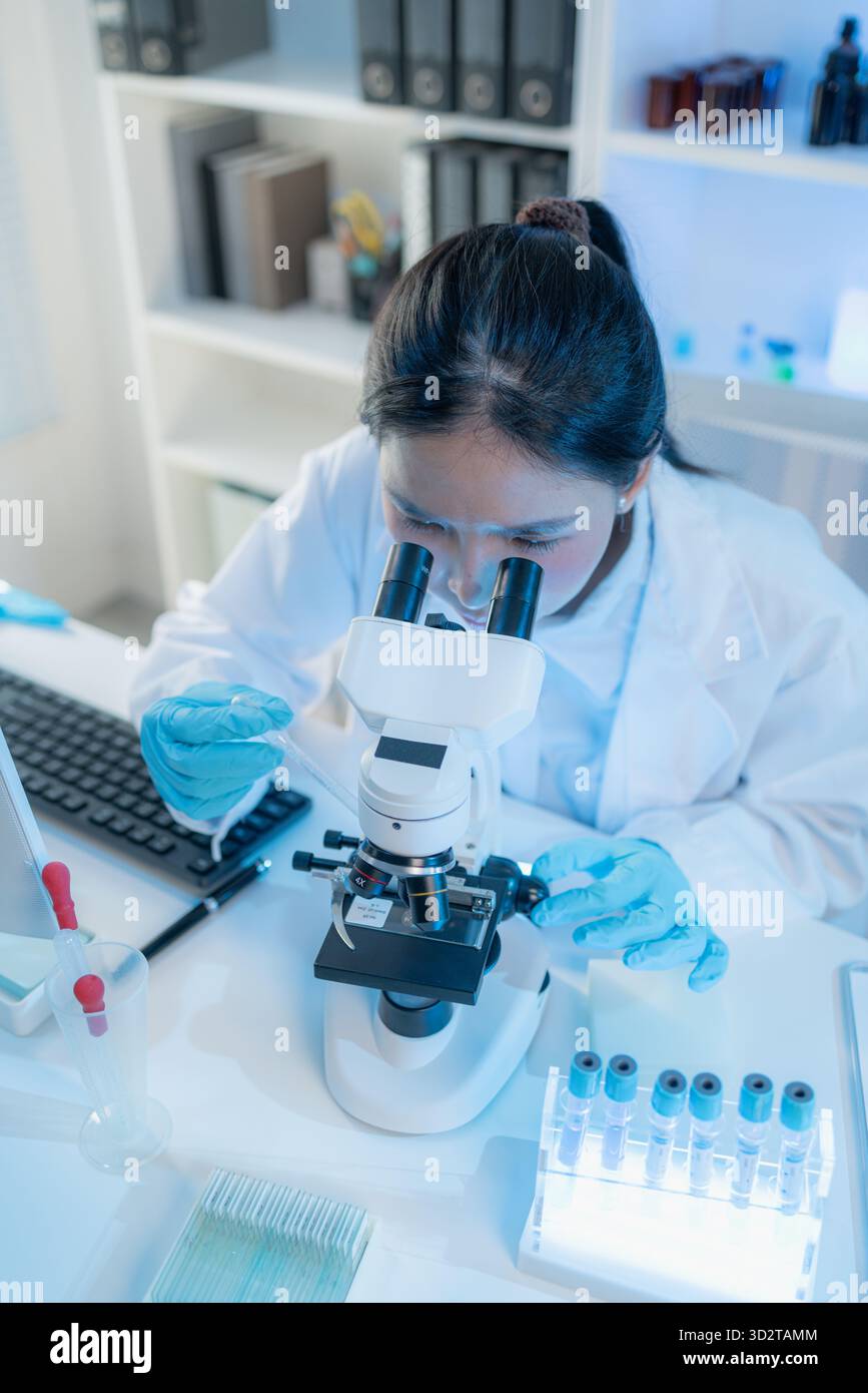 Chercheur en chimie dans un laboratoire entouré d'équipements scientifiques et de tubes à essai, représentant l'innovation, le développement scientifique et moderne Banque D'Images