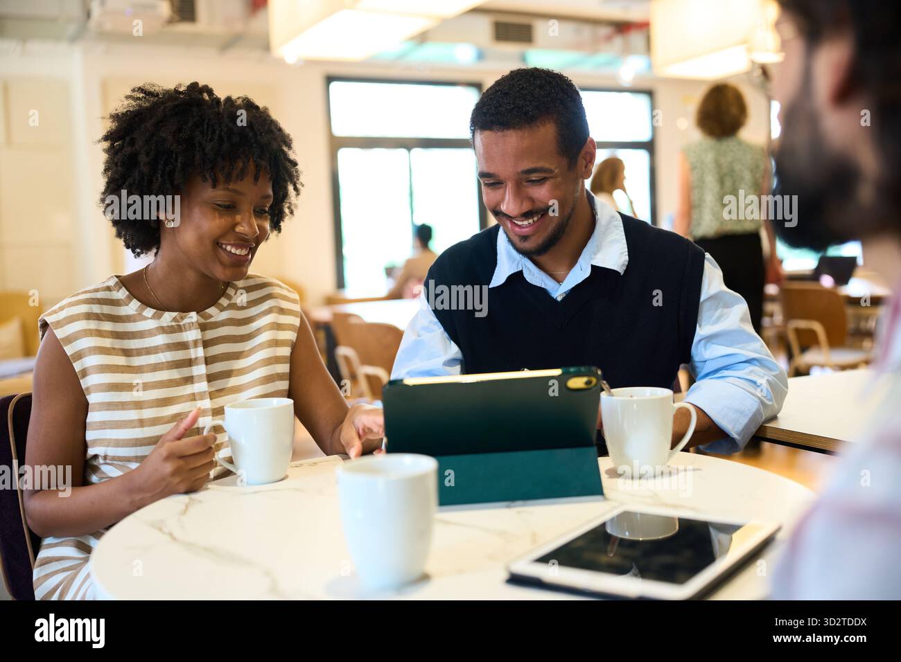 Équipe diversifiée collaborant sur tablette pendant la réunion d'affaires Banque D'Images