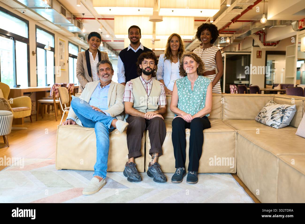 Équipe d'affaires diversifiée souriant au bureau de coworking moderne Banque D'Images