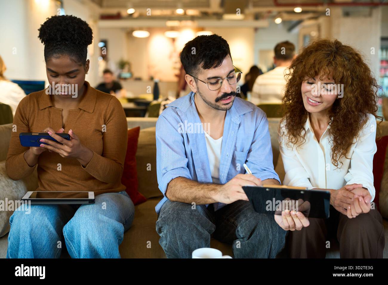 Équipe diversifiée collaborant dans un espace de coworking détendu - conseil financier, d'assurance et juridique Banque D'Images