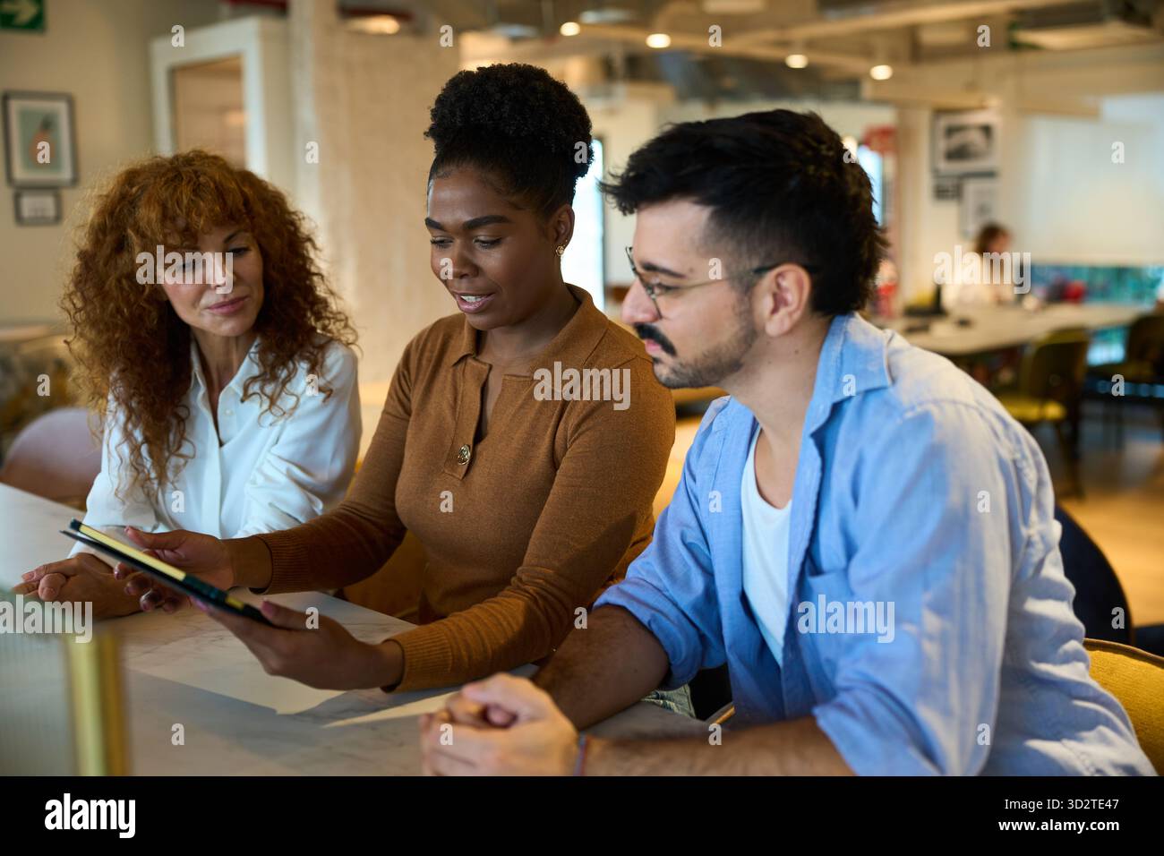 Équipe commerciale diversifiée collaborant sur tablette au bureau Banque D'Images