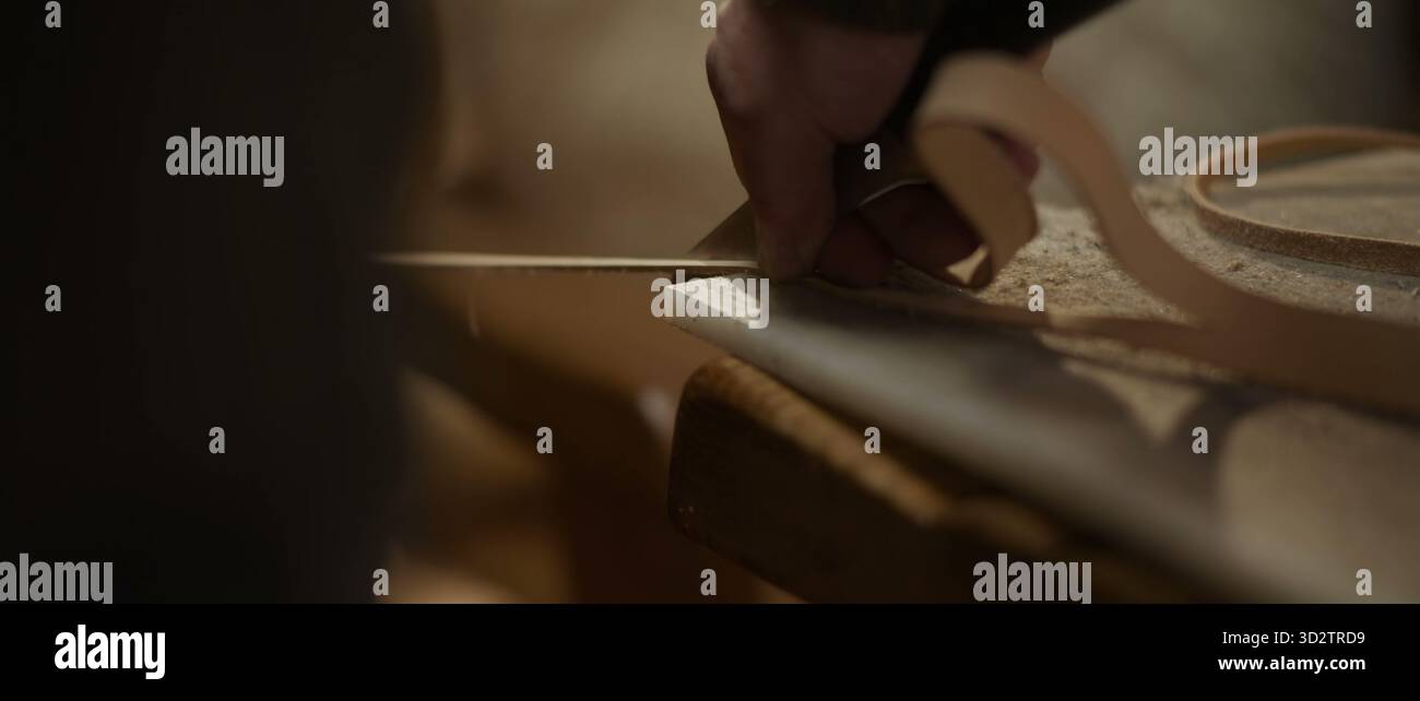 Les mains guident la bande de bois le long d'un banc poussiéreux avec un savoir-faire concentré Banque D'Images