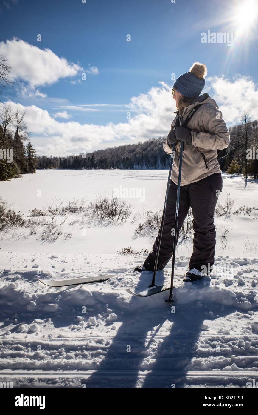 Une skieuse de fond regarde à travers un lac enneigé Banque D'Images