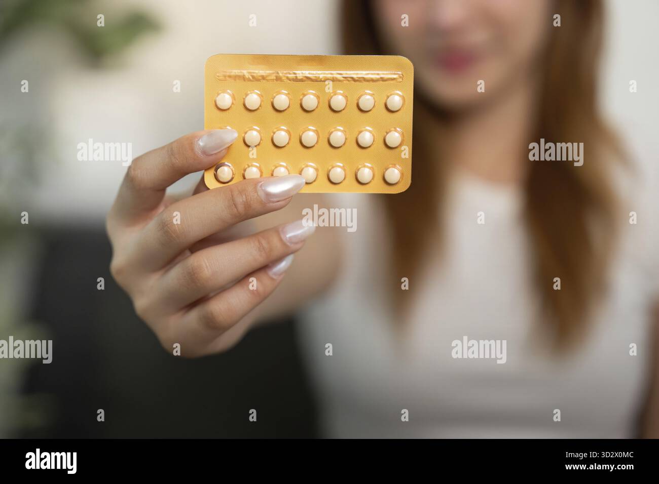 Une femme présente son paquet de pilules contraceptives, soulignant sa conscience de la santé et des choix personnels Banque D'Images