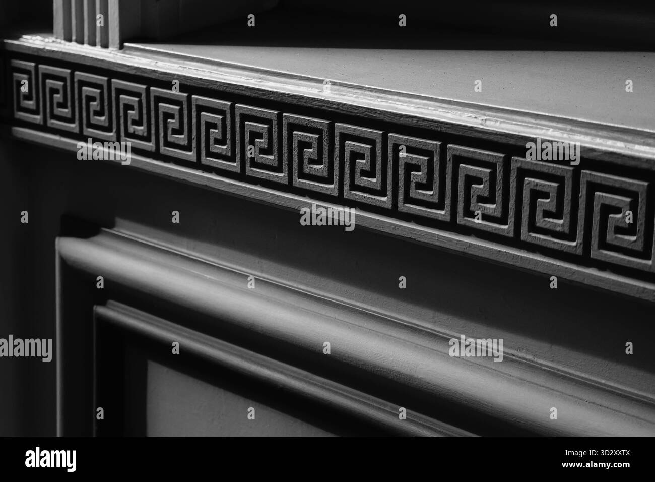 Fond noir et blanc avec des éléments architecturaux néoclassiques, motif de méandres et moulures murales en plâtre ou en béton. Banque D'Images