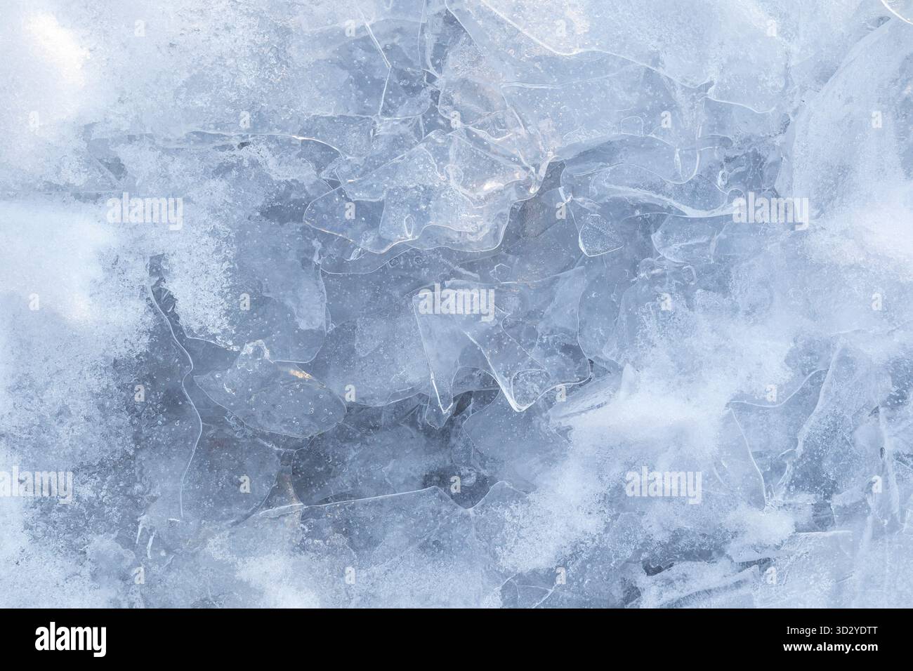 Gros plan de neige et de glace transparente sur un lac gelé en hiver, vu d'en haut. Fond hivernal abstrait, lumineux et texturé. Copier l'espace. Banque D'Images