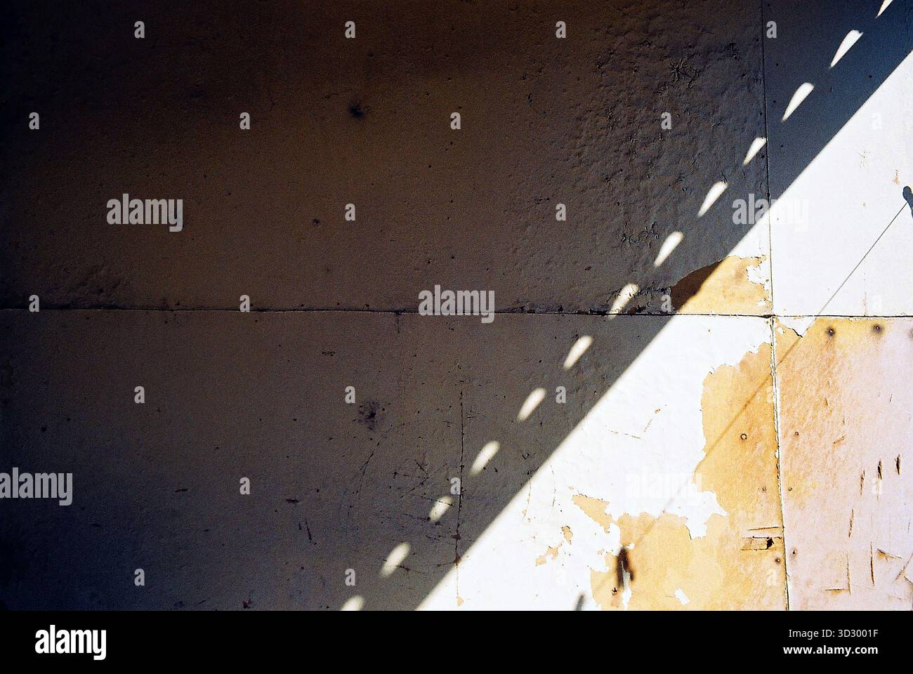 Panneaux lesonite avec une ombre diagonale, rayés et usés, montrant une texture analogique riche et des détails de surface subtils. Banque D'Images