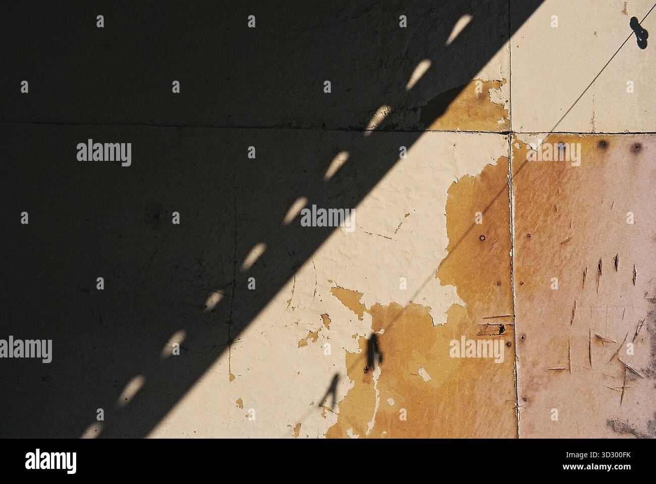Panneaux lesonite avec une ombre diagonale, rayés et usés, montrant une texture analogique riche et des détails de surface subtils. Banque D'Images