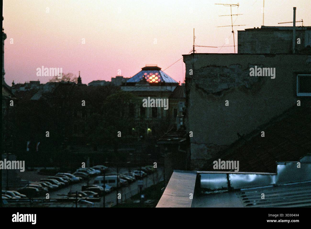 Vue depuis une terrasse vers un dôme en verre transparent au coucher du soleil, éclatant dans une lumière chaude et capturé dans des tons analogiques doux. Banque D'Images