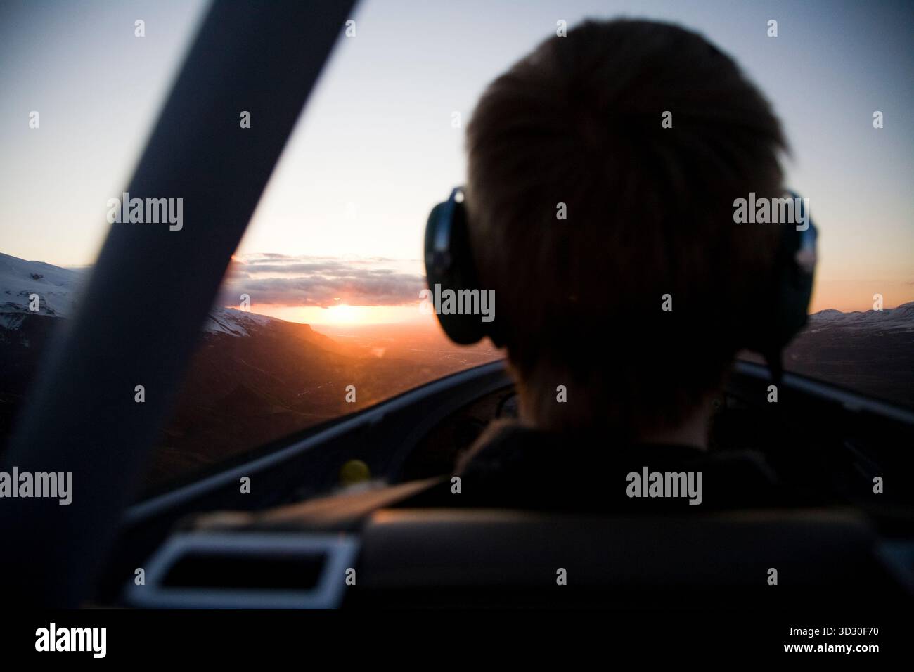 Pilote volant dans le coucher du soleil près de Eyjafjallajokull, Islande. Banque D'Images