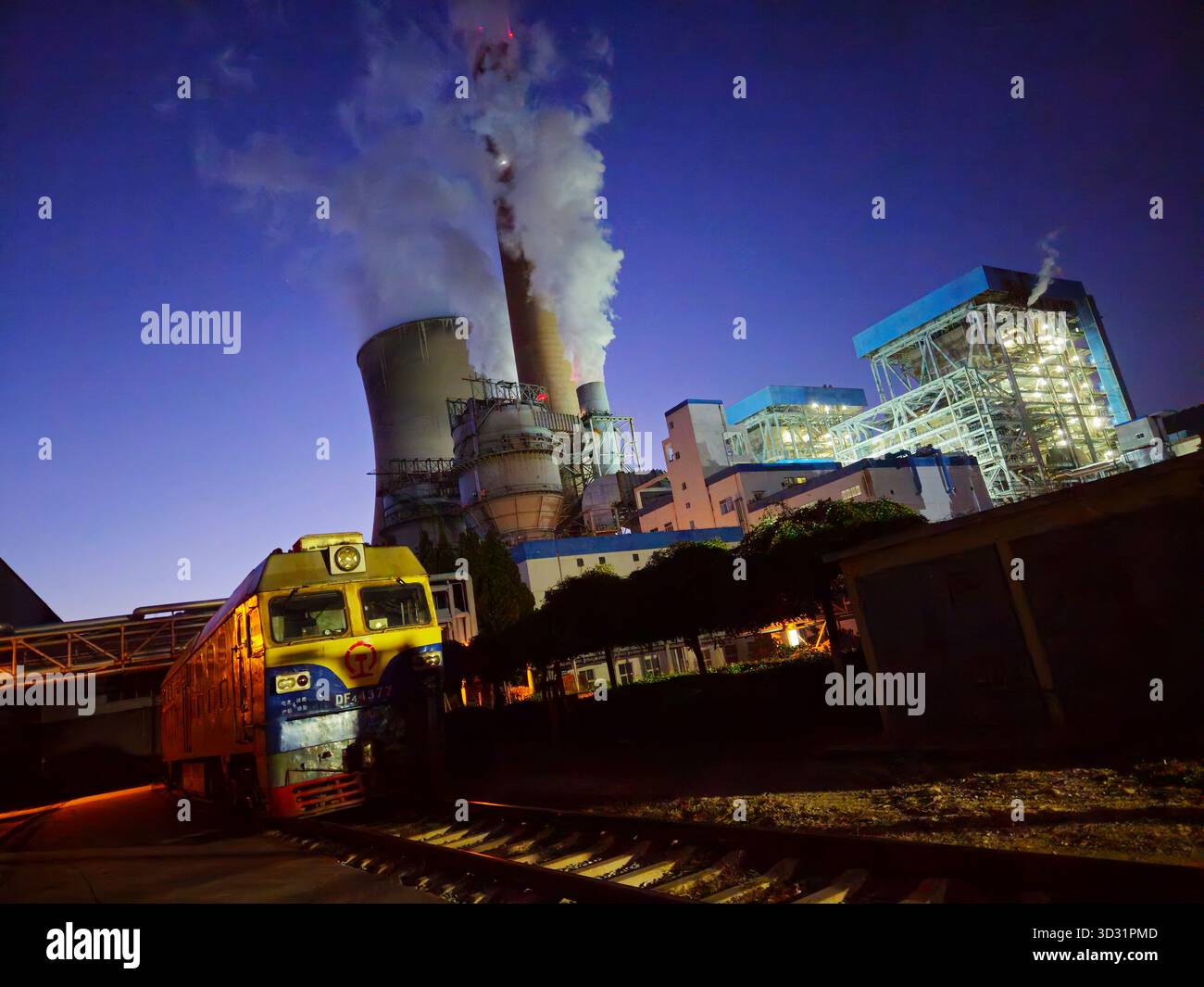 Centrale thermique au charbon avec locomotive de fret au crépuscule dans le Shandong, en Chine Banque D'Images