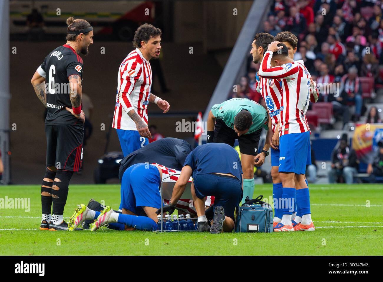 Un arbitre regarde un joueur de l'Atlético de Madrid sur le terrain lors du match LaLiga EA Sports entre l'Atlético de Madrid et le Sevilla FC Banque D'Images