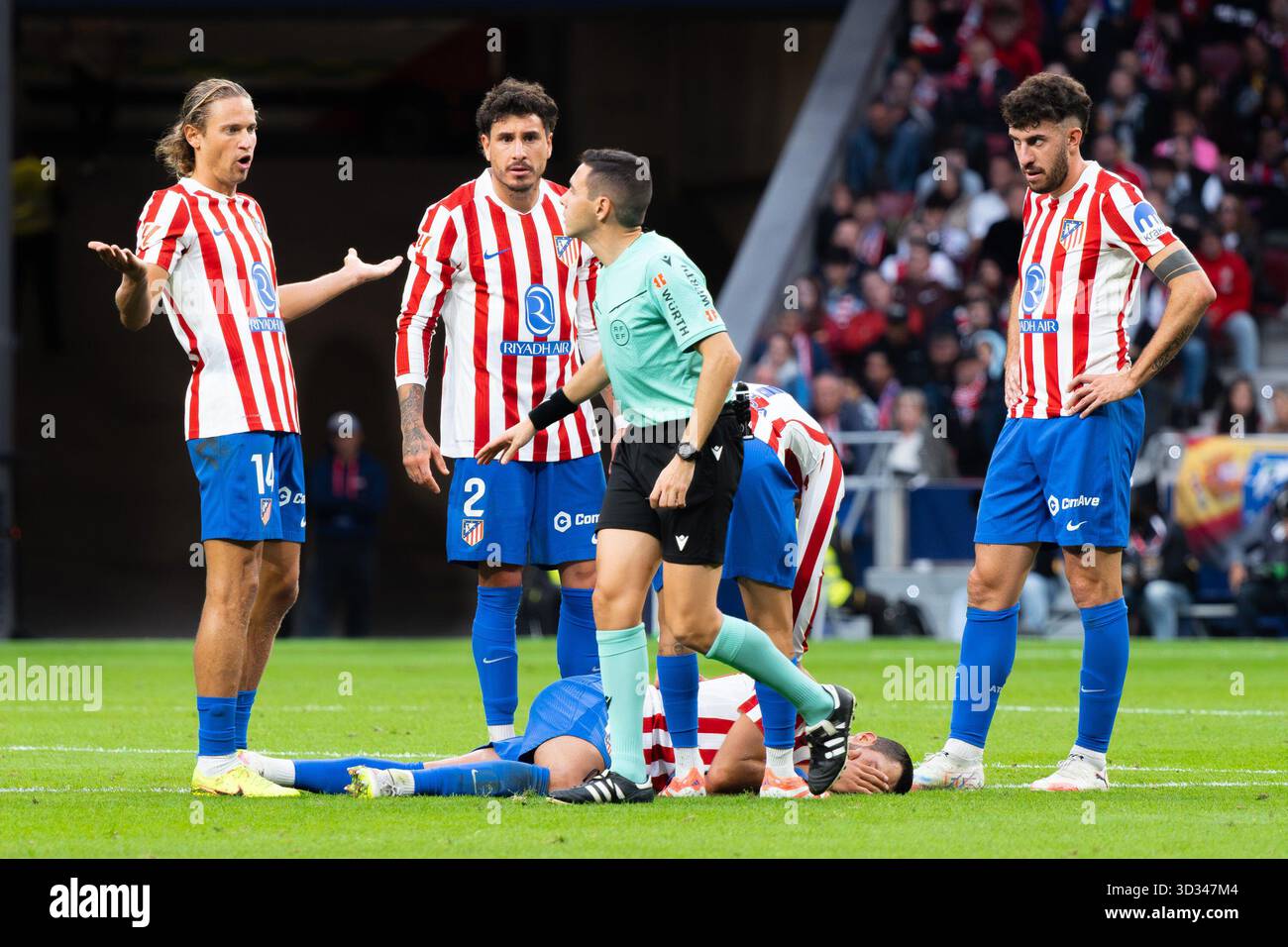 Un arbitre regarde un joueur de l'Atlético de Madrid sur le terrain lors du match LaLiga EA Sports entre l'Atlético de Madrid et le Sevilla FC Banque D'Images