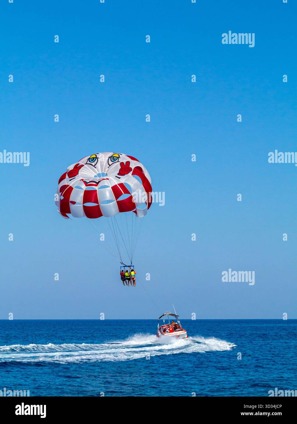 Touristes parachute ascensionnel ou parachute ascensionnel à partir d'un bateau à moteur dans la mer Méditerranée au large de la côte de Protaras dans l'est de Chypre. Banque D'Images