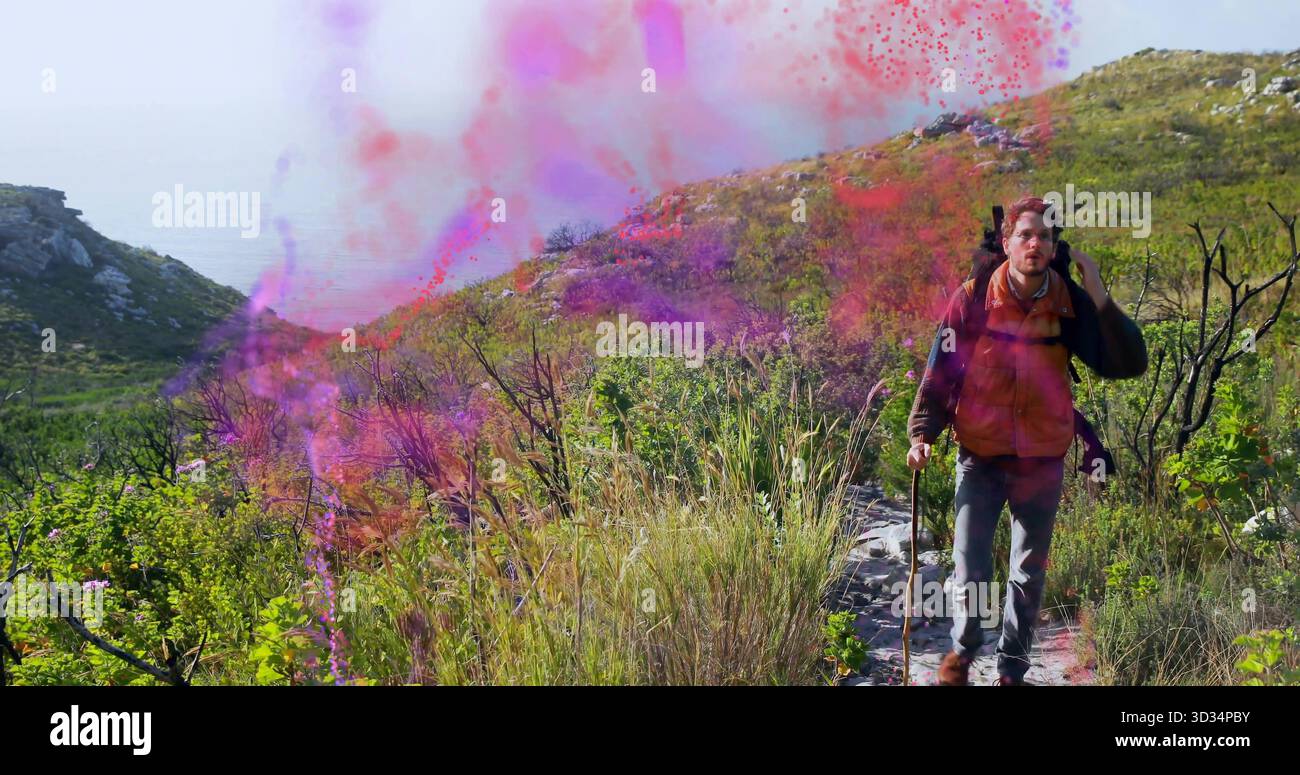 Homme de randonnée tenant bâton portant sac à dos sur un sentier rocheux avec des nuages de poudre colorés, espace de copie Banque D'Images