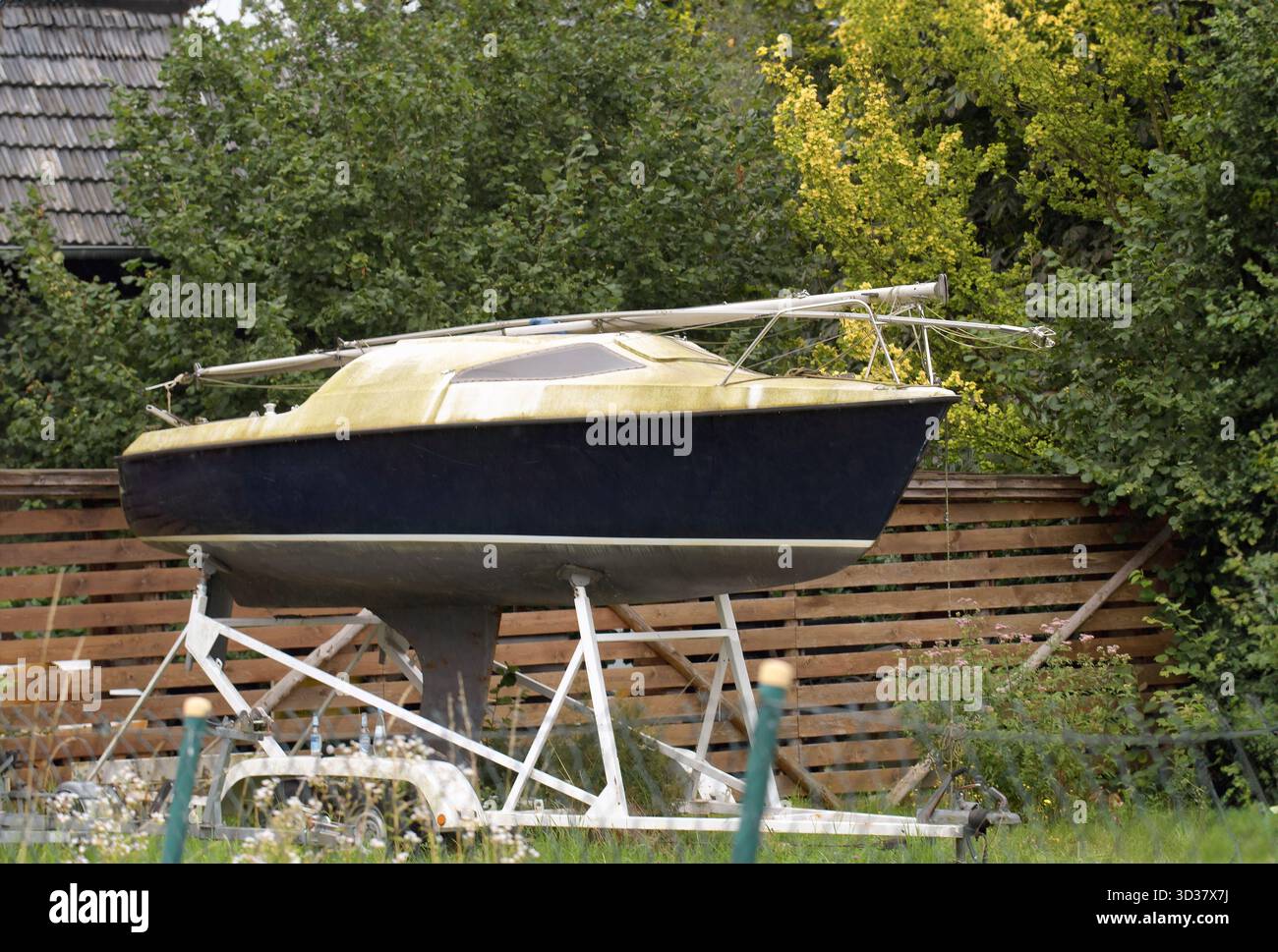 Bateau inutilisé amarré dans une cour d'une maison sans moteur sur un stand spécial Banque D'Images