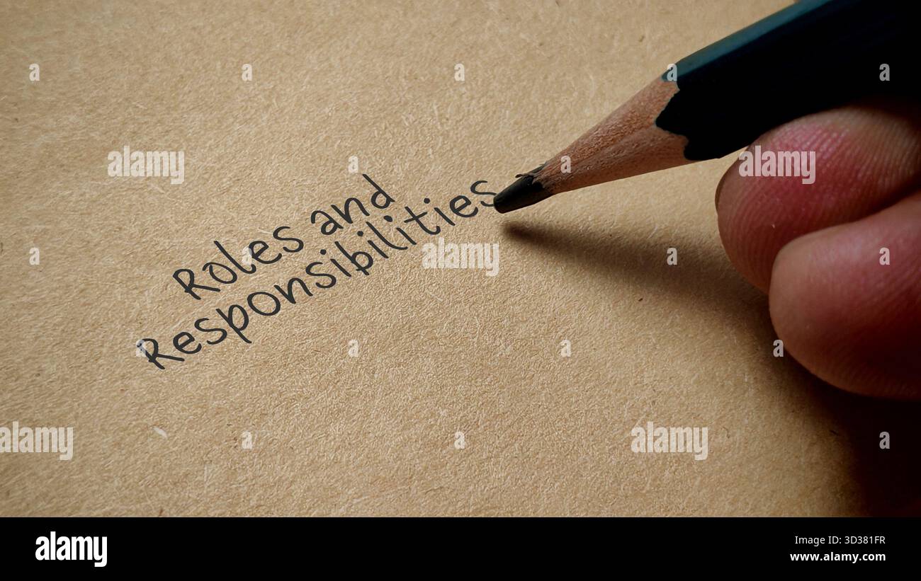 Écriture manuscrite rôles et responsabilités au crayon sur papier brun Description de travail concept d'affaires Banque D'Images