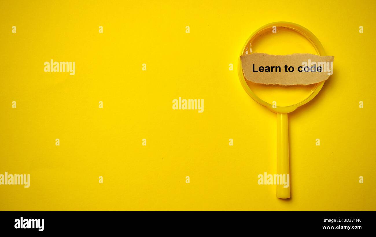 Message essentiel « apprendre à coder » souligné par une loupe jaune, symbolisant la plongée profonde dans la technologie et le développement des compétences. Banque D'Images